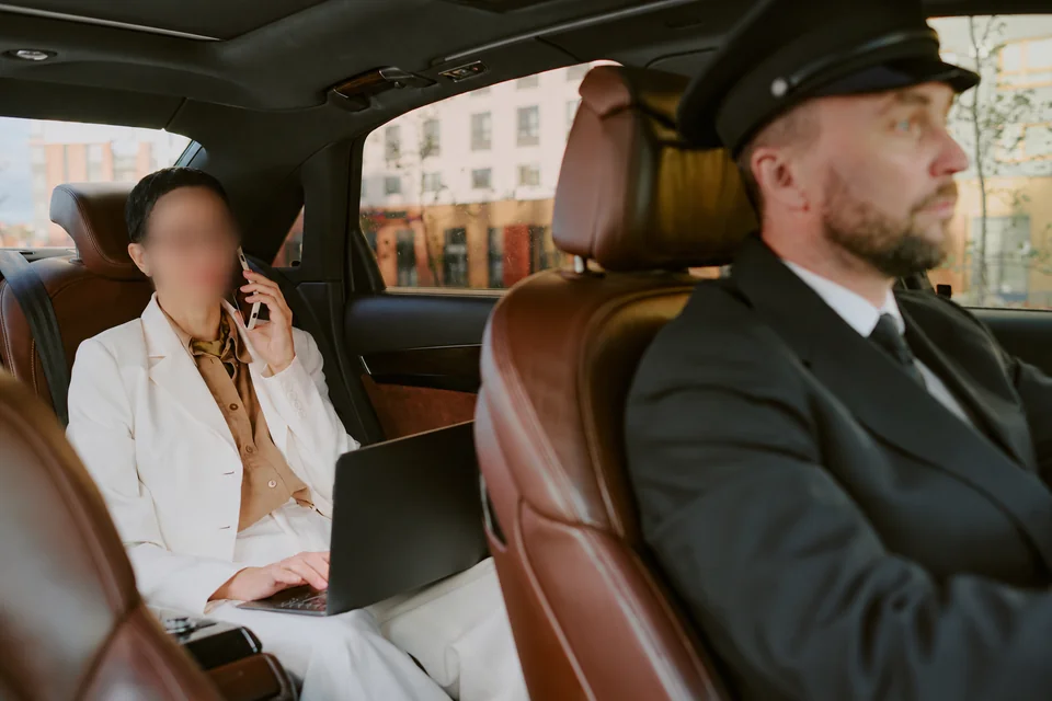 Une passagère travaille à l’arrière d’une voiture avec chauffeur